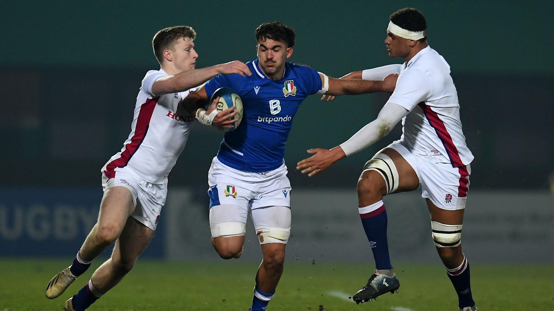 Rugbista italiano cerca di evitare il placcaggio di due inglesi