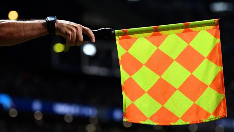 Arbitro alza la bandierina del fuorigioco