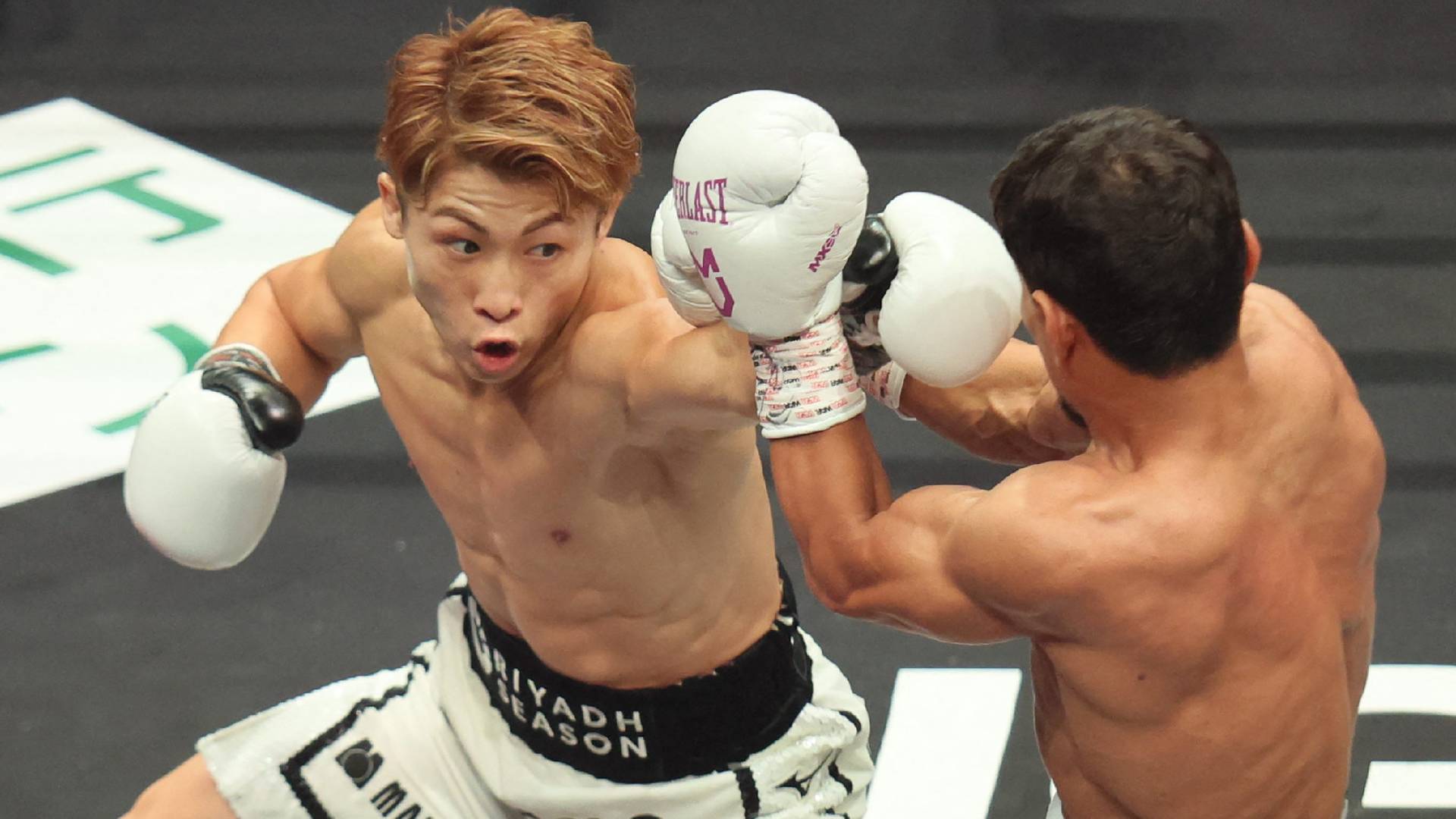 Japan's Naoya Inoue (L) fights against Uzbekistan's Murodjon Akhmadaliev during their super bantamweight boxing title fight