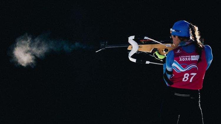 Atleta di biathlon spara durante una gara olimpica