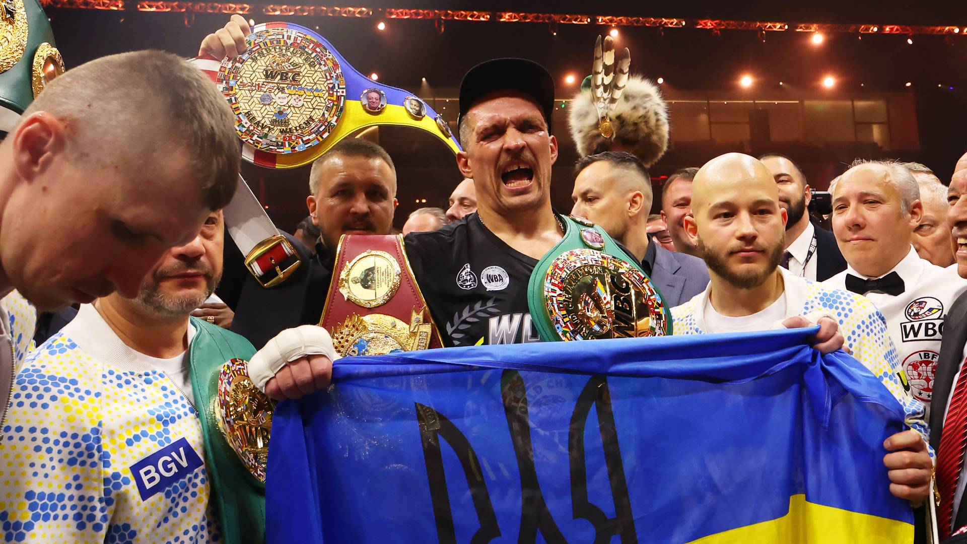 Oleksandr Usyk holds a Ukrainian flag as he celebrates with the Undisputed Heavyweight title belt