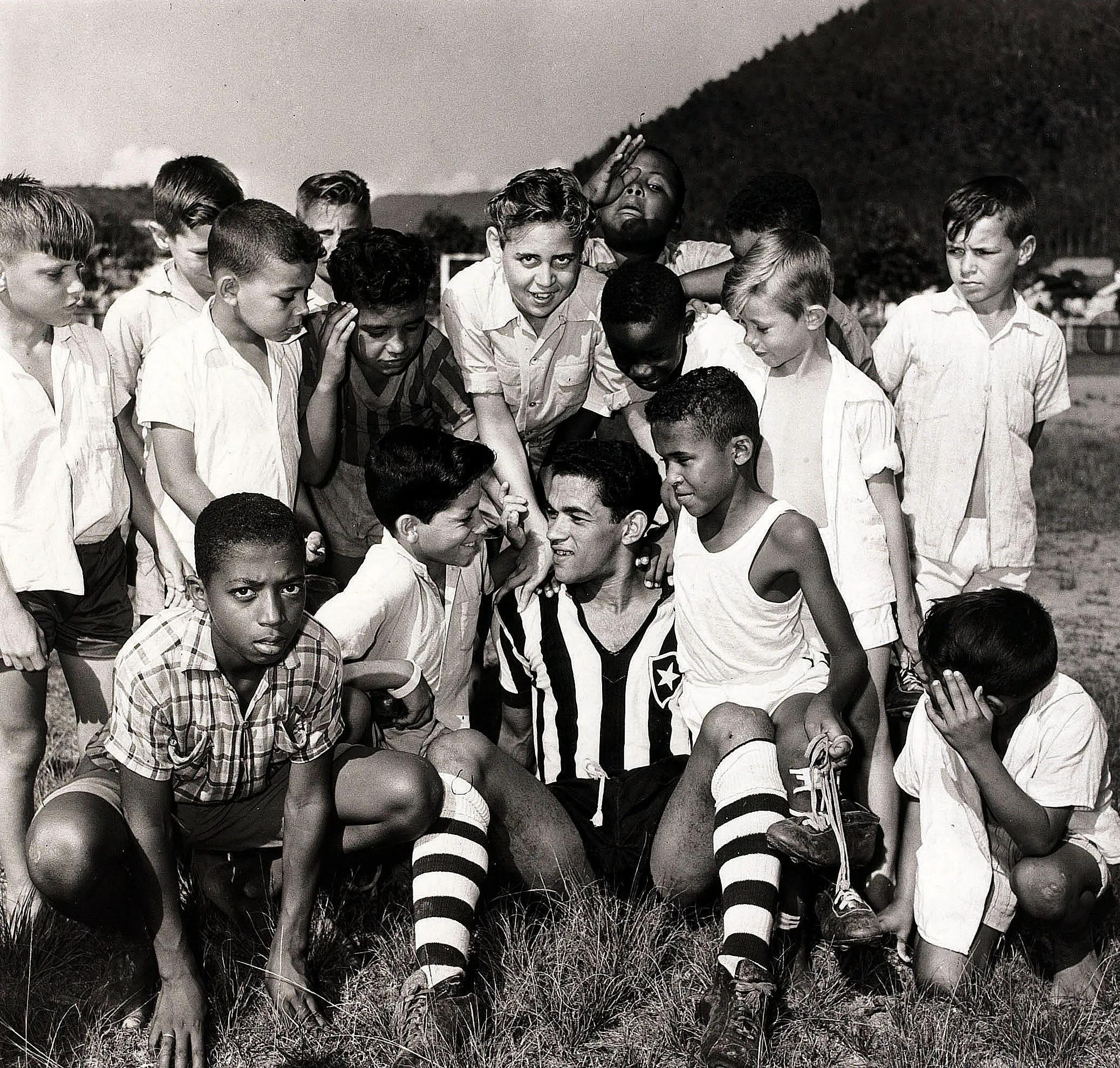 transform-30c5cfa2-61db-483a-9c57-85d0cc222737-Botafogo-and-Brazil-star-Garrincha-is-pictured-sitting-with-a-group-of-local-children-in-1957